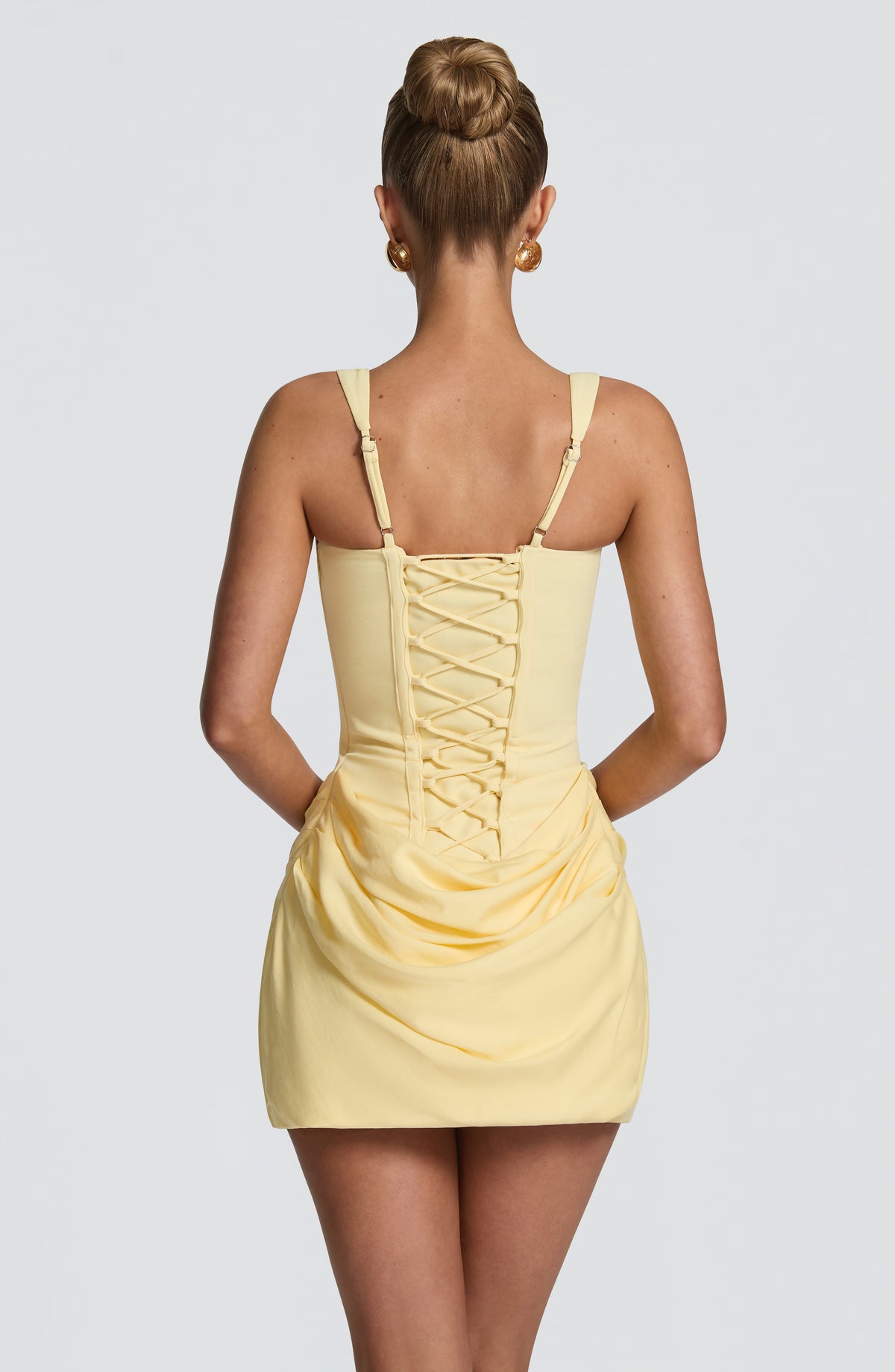 Back view of the pale yellow dress showing criss-cross lace-up corset back, adjustable straps and draped skirt. 26