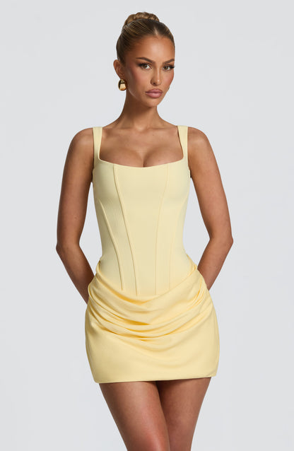 Pale yellow version of the dress from the front, close crop showing the boned corset bodice, wide straps and gathered drape. 25