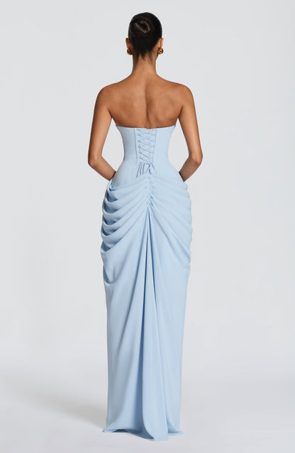 Back view of the pale blue dress showing the lace-up corset back and gathered, ruched skirt draping to the floor. 22