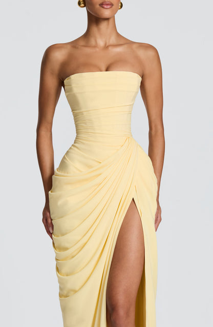 Close-up of the pale yellow dress from bust to thigh, showing the pleated corset bodice, ruched waist and draped wrap skirt. 5