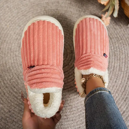 Pink ribbed slippers seen from above, one held to show the fleece lining and one worn on a foot. 10