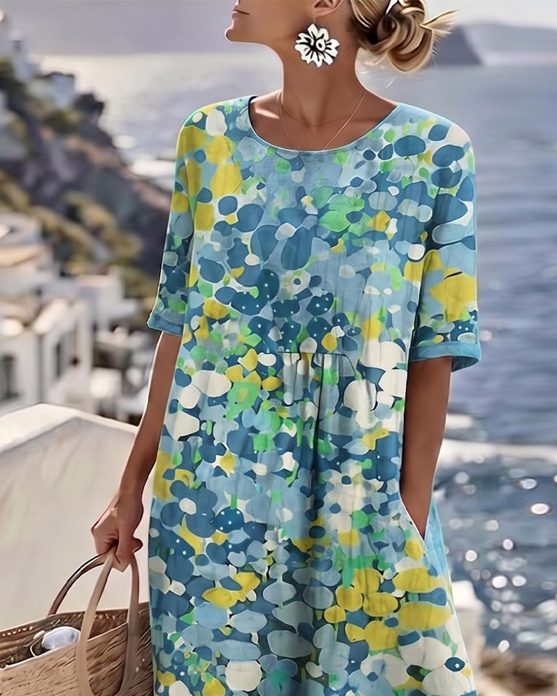 Close-up of the blue and yellow floral dress's round neckline and sleeves on a model 12