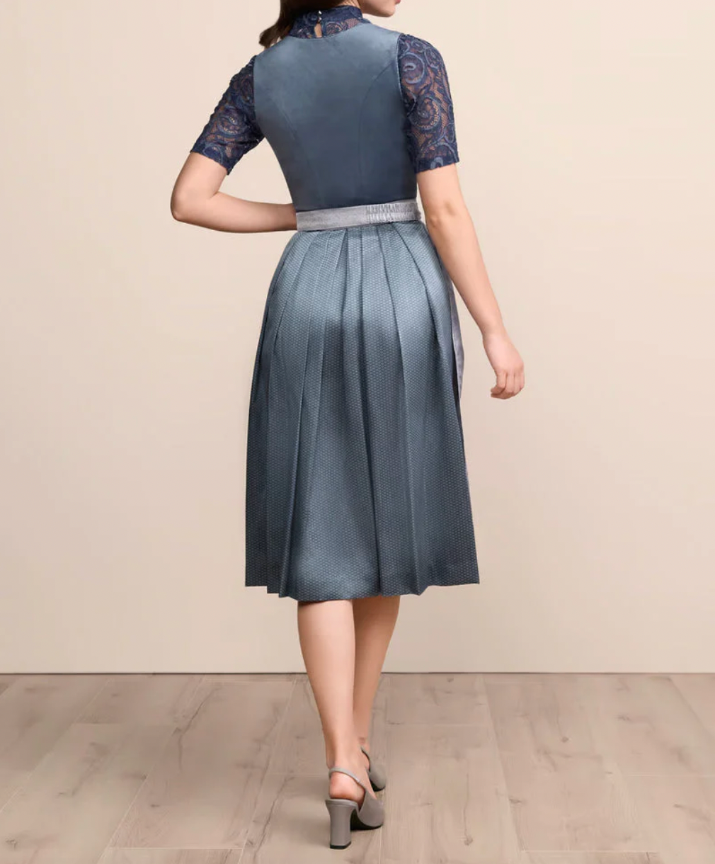 Back view of the model showing the plain bodice, lace sleeves and full pleated skirt falling to below the knee. 3