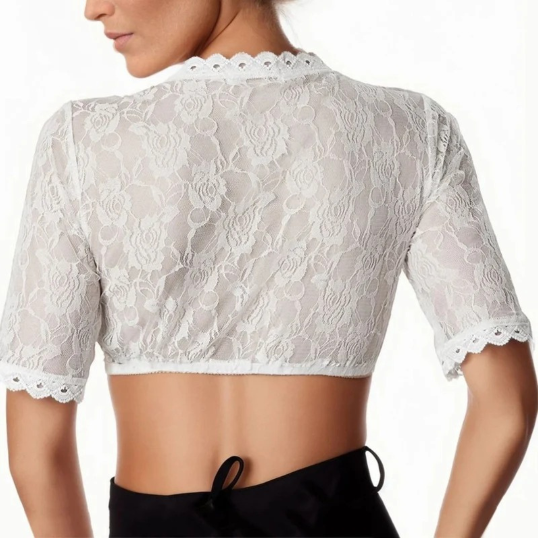 Back view on a model, showing the sheer floral lace across the back, scalloped neckline and sleeve edges, worn over black bottoms. 2