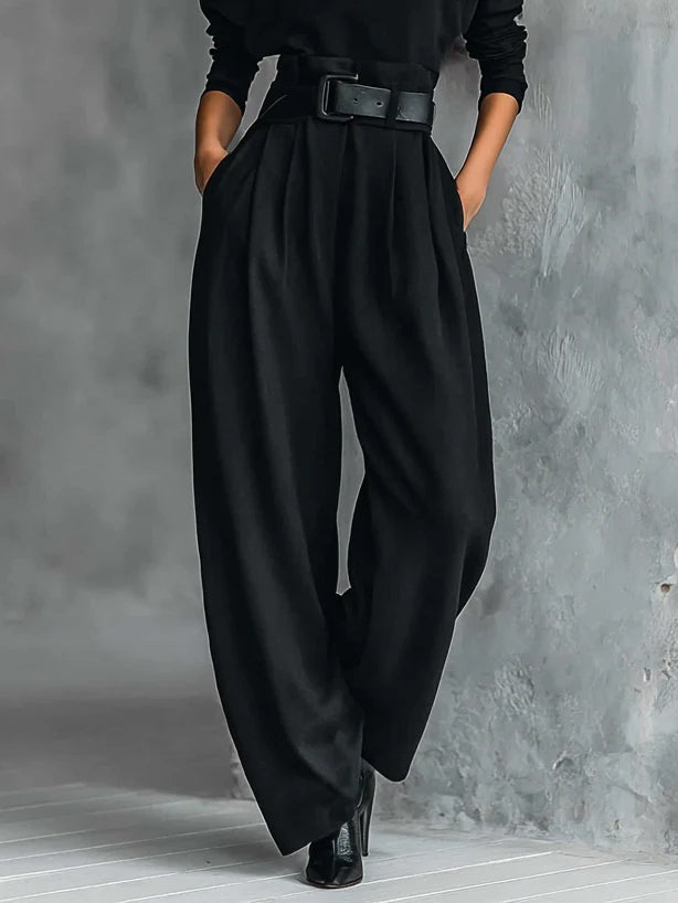 Black wide leg trousers with front pleats and belt, shown from the waist down with ankle boots 4