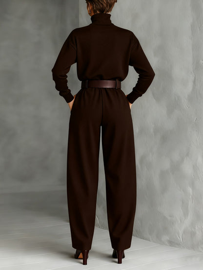 Back view of the dark brown set on a model, with belt at the waist and heeled boots 6