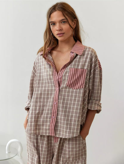 Front view of the pink check pyjama shirt with striped placket and chest pocket, worn open at the collar with sleeves rolled. 4