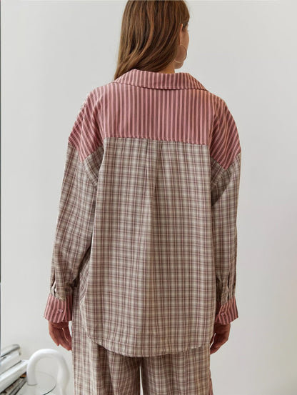 Back view of the pink pyjama shirt, with a striped yoke and collar above the check body and striped cuffs. 8