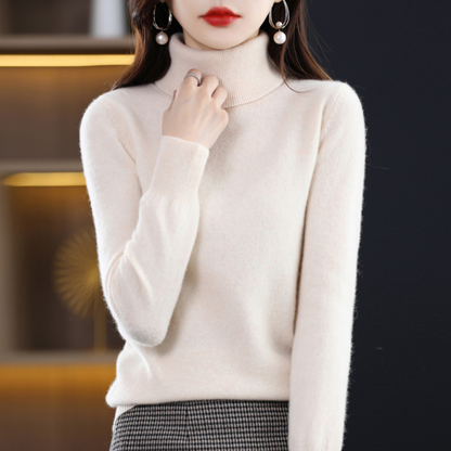 Model in the roll neck jumper in cream, one hand touching the collar, worn with a houndstooth skirt. 15
