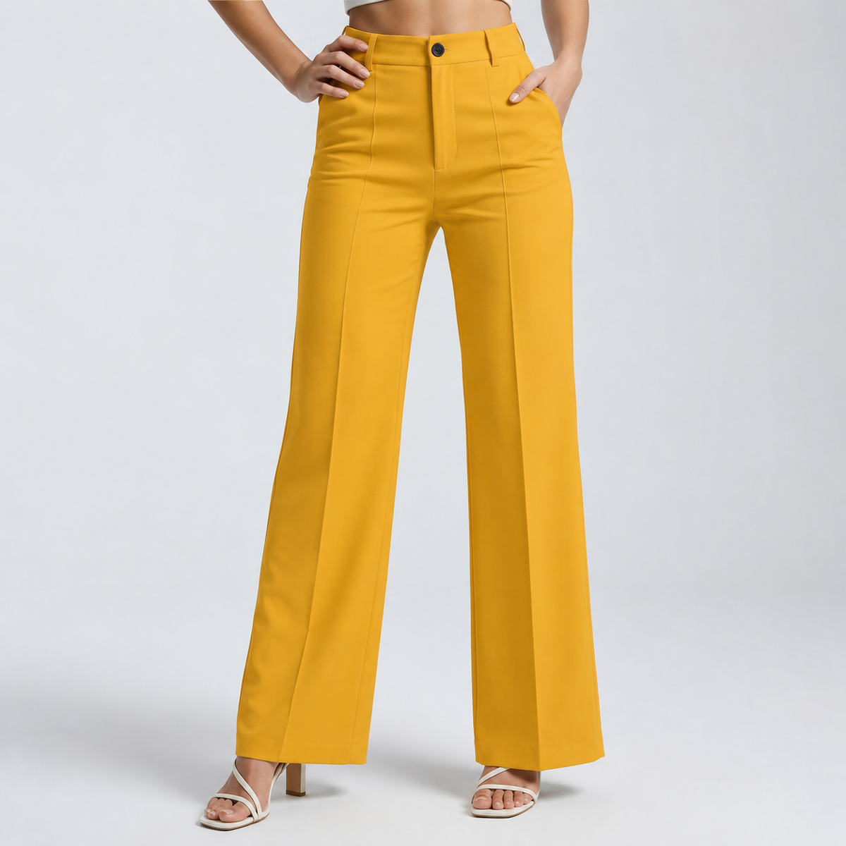 Mustard yellow trousers on a model with one hand on the hip and one in a pocket 17