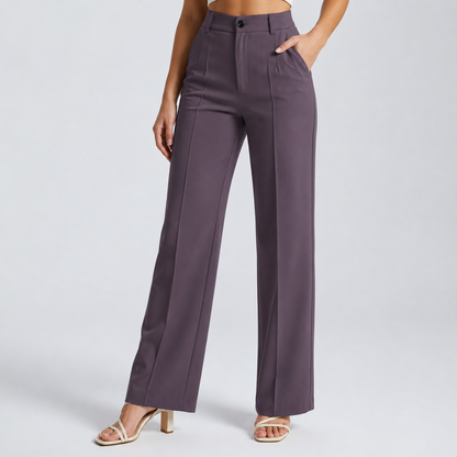 Model wearing dusky purple high-waisted trousers with a front crease and one hand in the pocket, with cream sandals 22