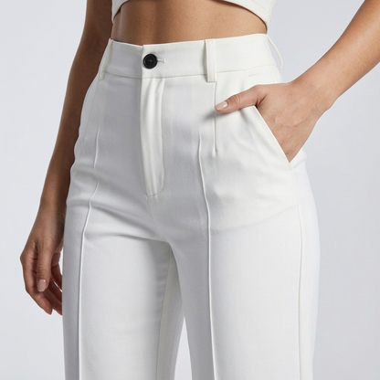 Close-up of the front of white trousers showing the button fastening, waistband, pleat and side pocket 6
