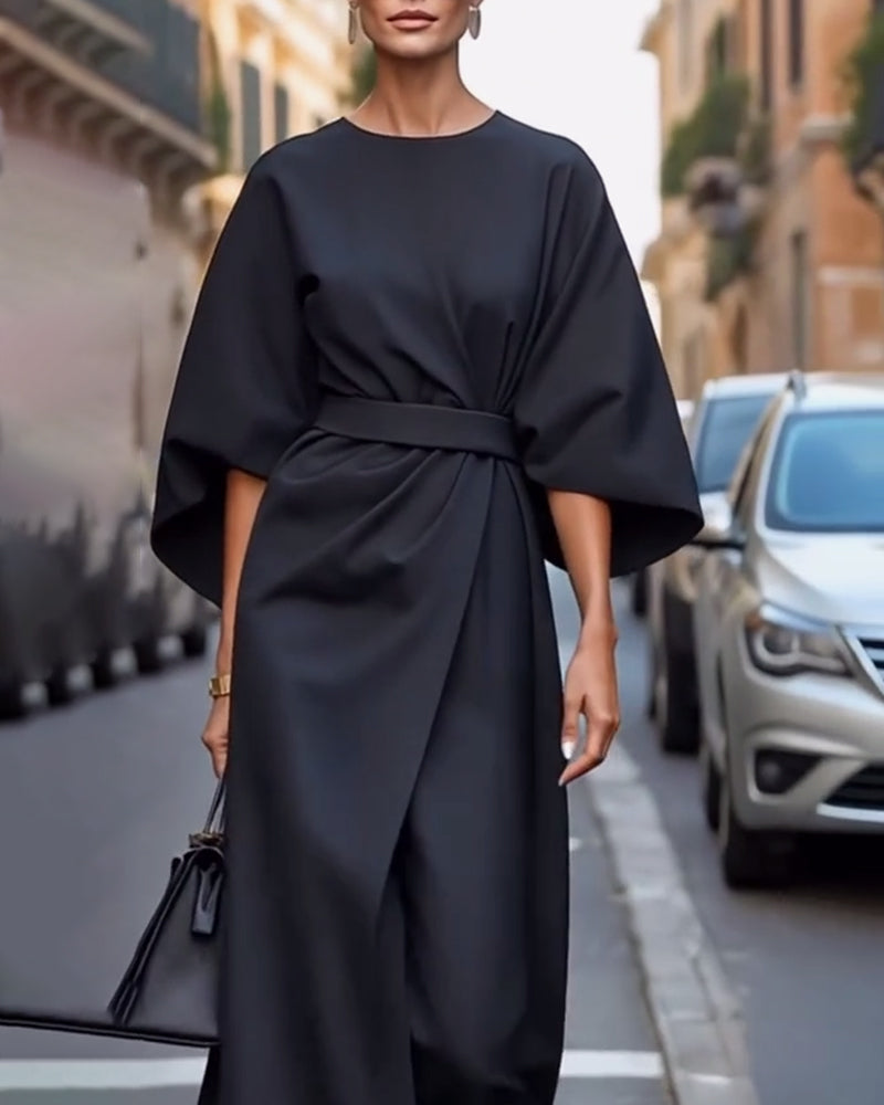 Black belted dress with wide batwing sleeves, shot from head to knee beside parked cars 4