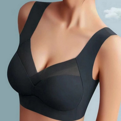 Model wearing the seamless bra in black, showing the sheer mesh V-neck inset and wide straps 3