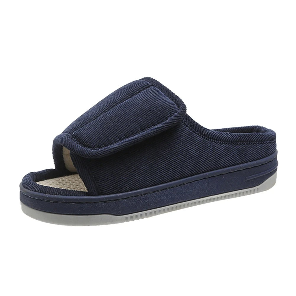 Single navy corduroy open-toe slipper with a wide adjustable strap, woven insole and a thick grey tread sole, shown at an angle. 4