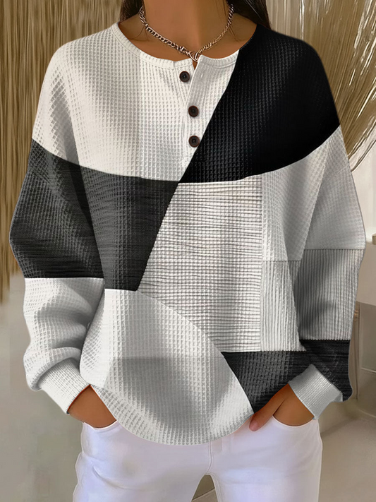 Waffle knit henley jumper in black, grey and white geometric colour-block panels, worn by a model 2