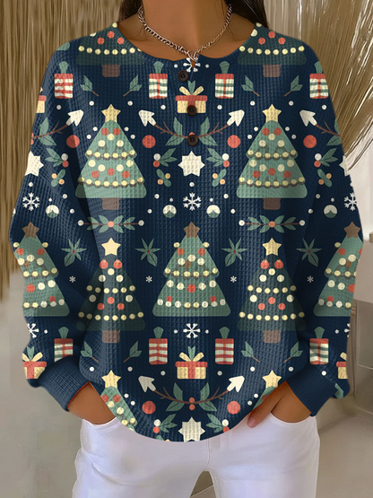 Navy waffle knit jumper printed with green Christmas trees, wrapped gifts and snowflakes, worn by a model 8
