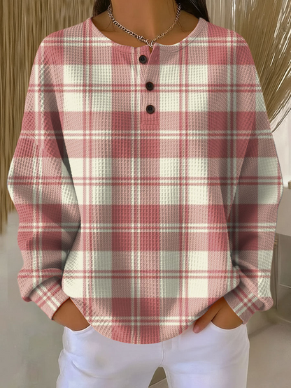 Waffle knit henley jumper in a pink and cream tartan check pattern, worn by a model 15