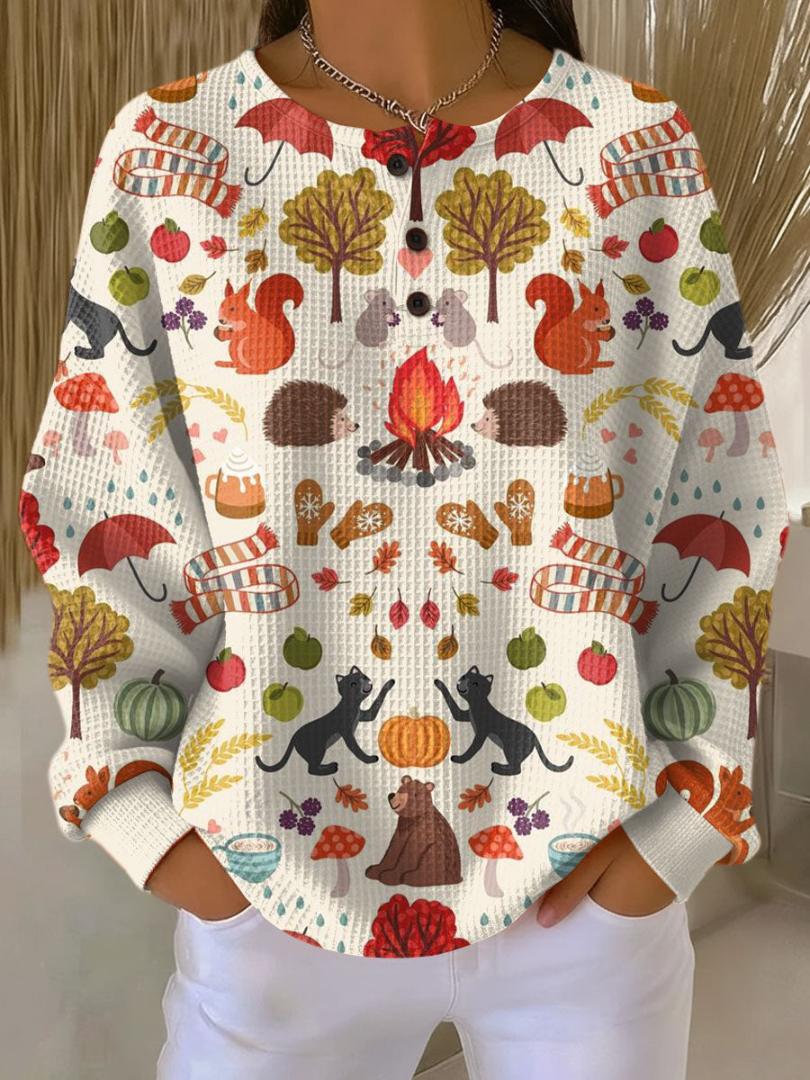Cream waffle knit jumper printed with autumn motifs including squirrels, hedgehogs, cats, a campfire and mushrooms 19