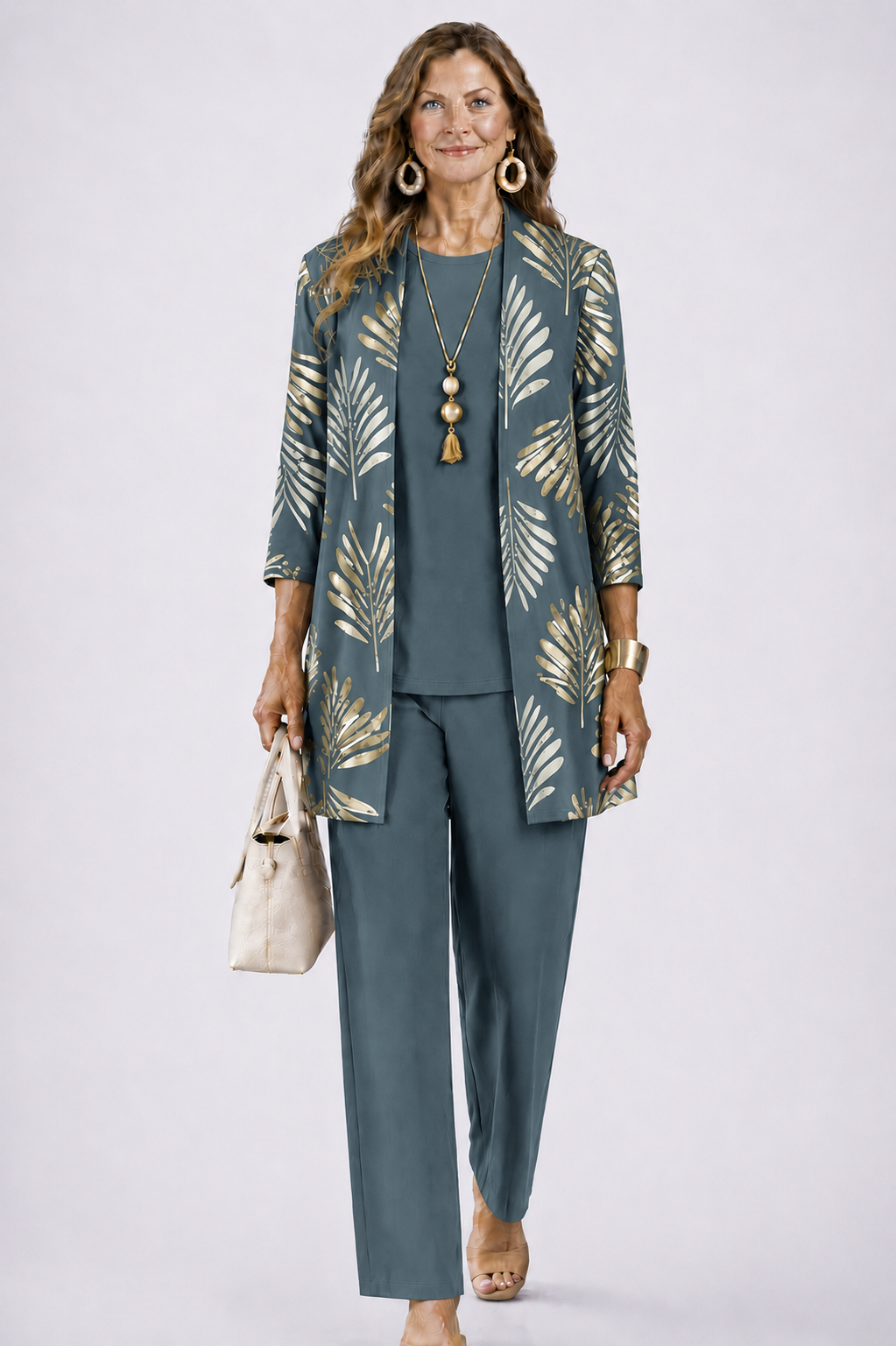 Model wears the set in slate teal with a gold leaf-print open cardigan, holding a cream handbag 1