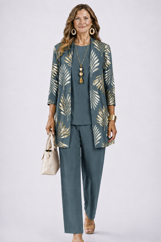 Model wears the set in slate teal with a gold leaf-print open cardigan, holding a cream handbag 1