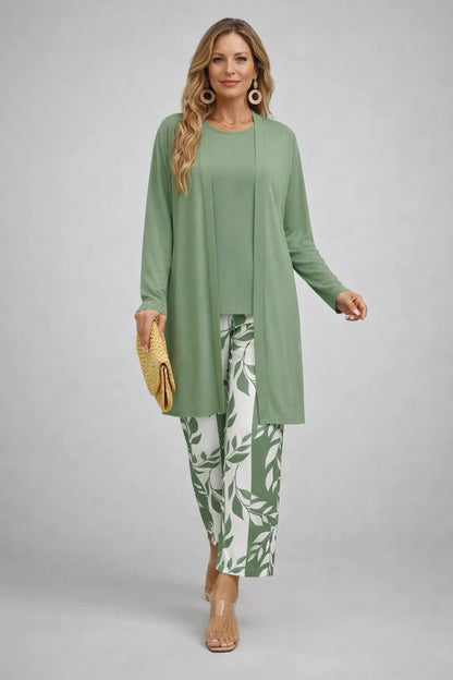 Model wears a sage green plain cardigan and top with green and white leaf-print trousers 10