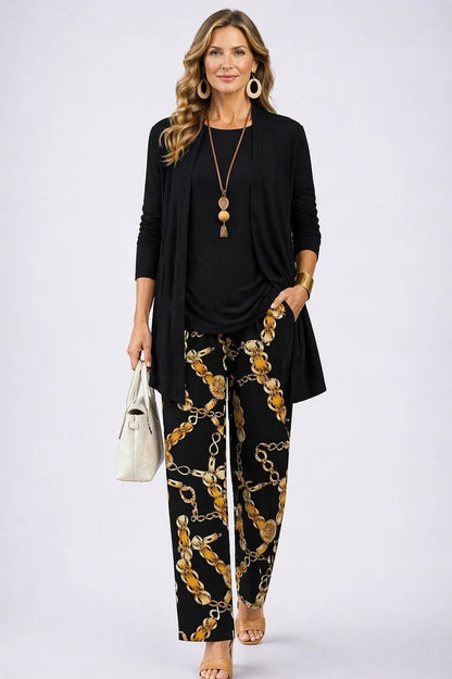 Model wears a plain black cardigan and top with black trousers printed with gold chain links 17