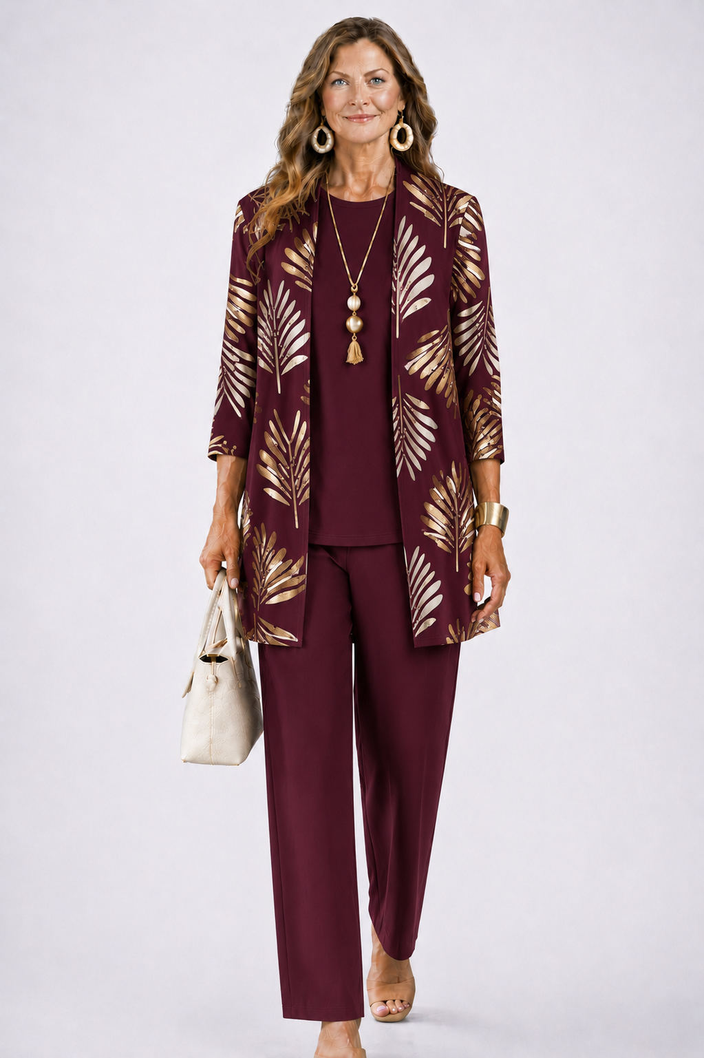 Model wears the burgundy set, the open cardigan printed with metallic gold palm leaves 6