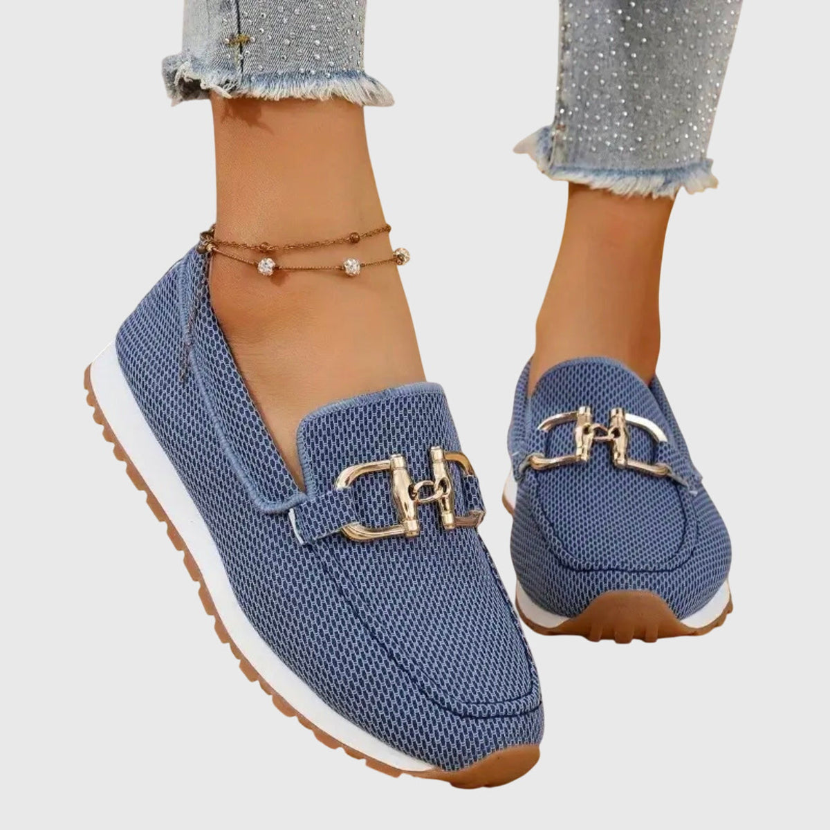 Blue mesh slip-on shoes with gold buckle worn by a model, angled view showing white sole 3