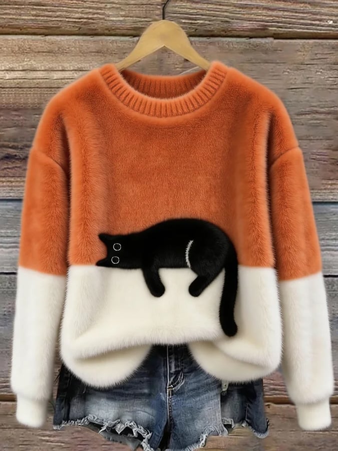 Orange and white fluffy jumper with black cat motif, hanging on a wooden background 4