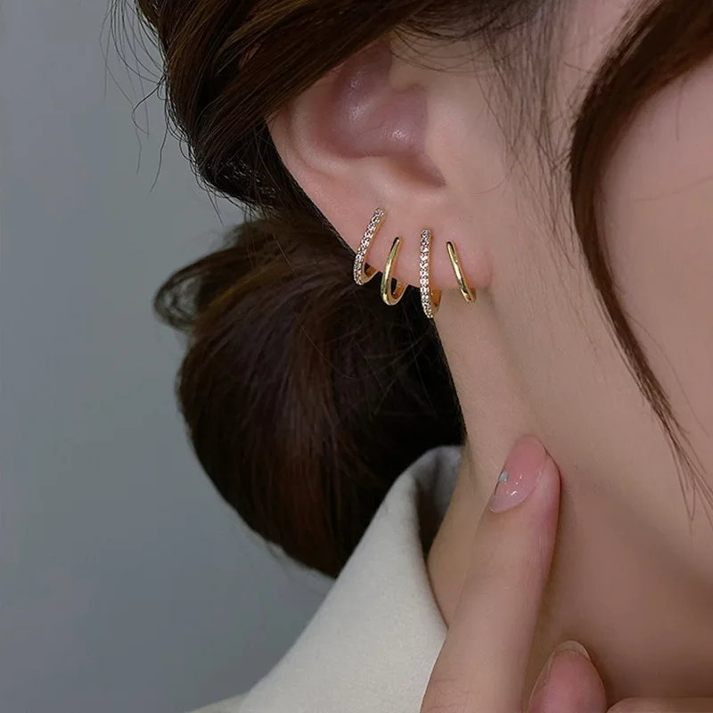 Close-up of the earring in the ear, showing alternating plain gold and sparkling stone-set bands 5