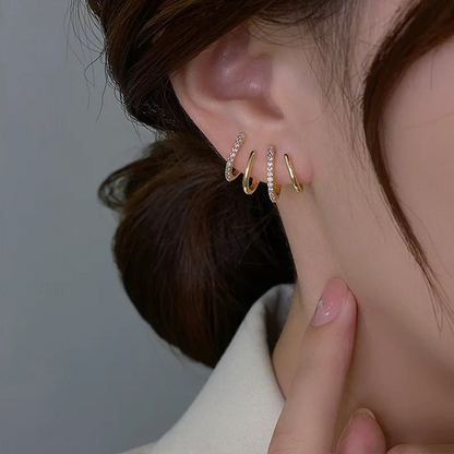 Close-up of the earring in the ear, showing alternating plain gold and sparkling stone-set bands 5