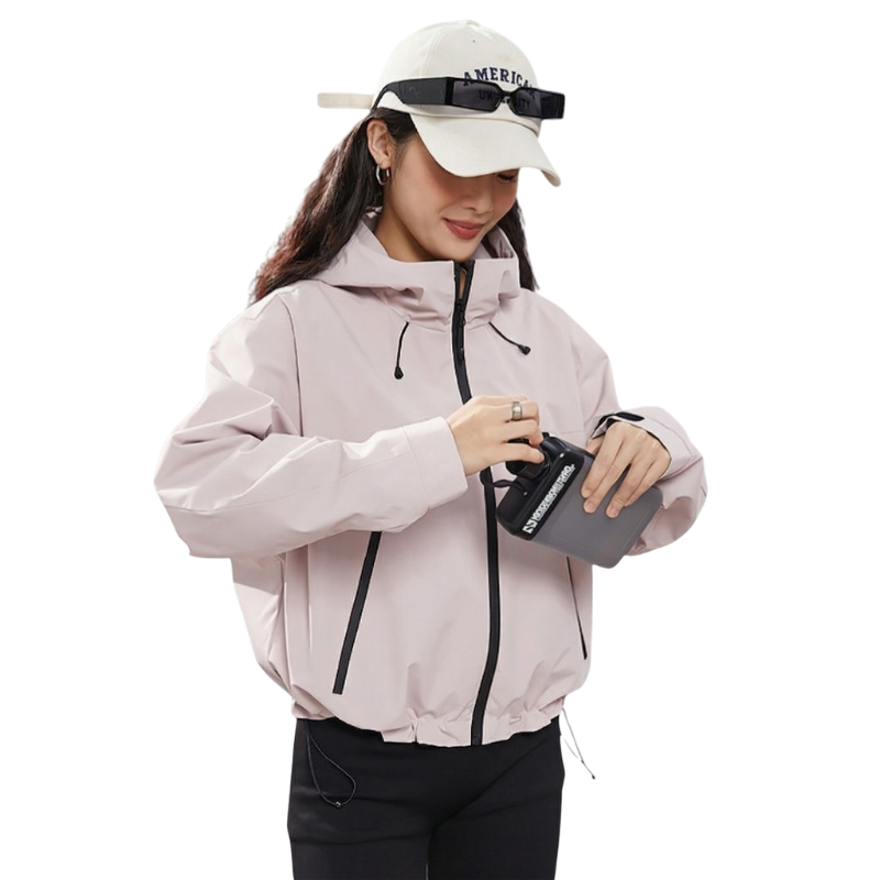 Woman in the pale pink jacket placing a small item into a front pocket 13