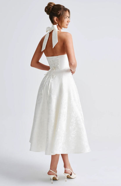 Back view of the ivory halter dress, showing the tied bow at the neck, open back and corset-style lace-up bodice. 3