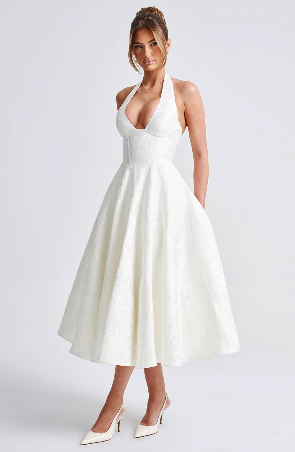 Three-quarter front view of the ivory halter dress on a model, showing the corset seams and full tonal floral jacquard skirt. 2