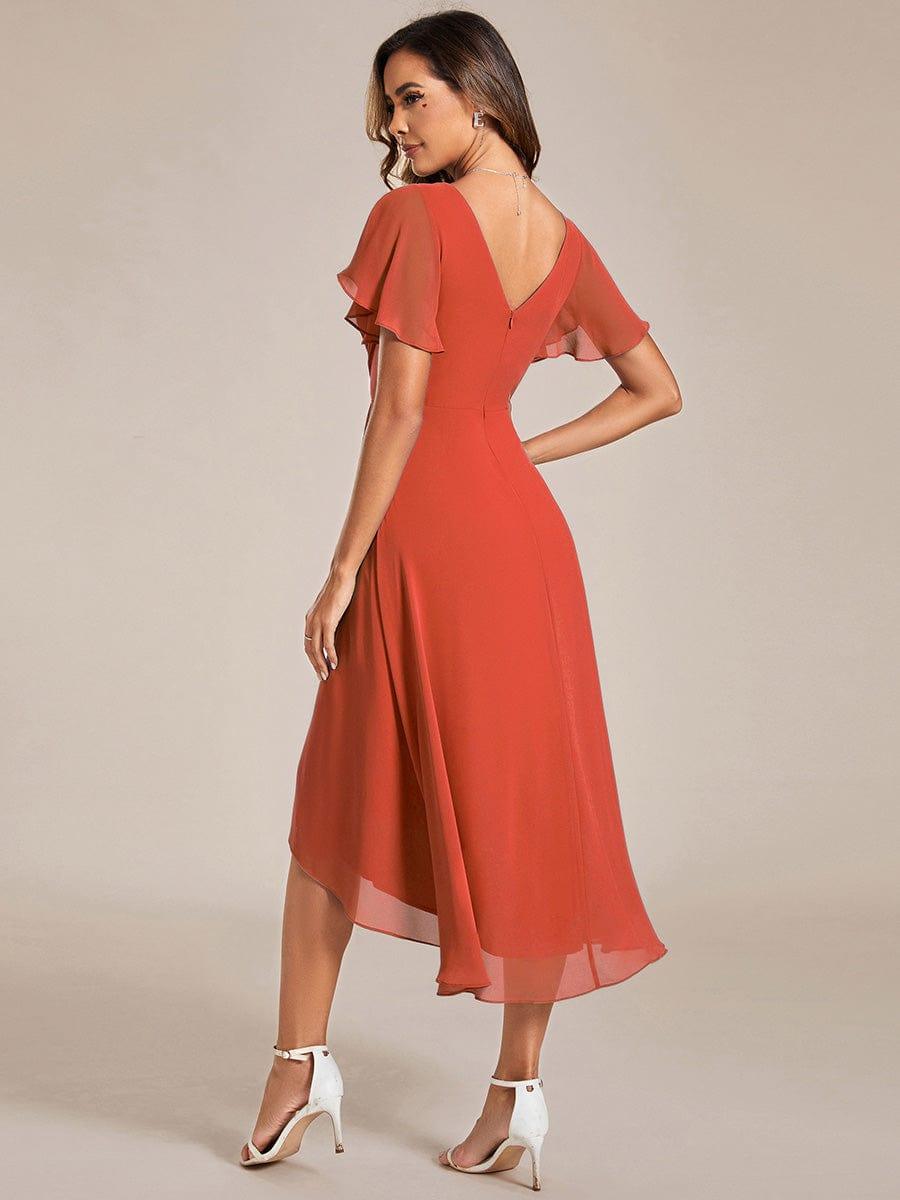 Back of the burnt orange dress on a model, showing the V-shaped back with zip and sweeping high-low hem. 93