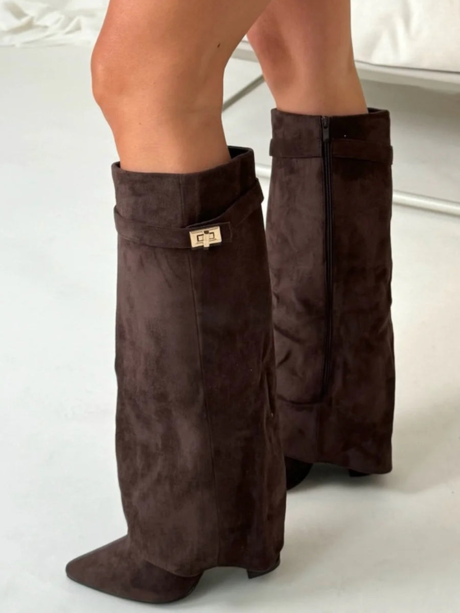 Close side view of dark brown suede-look knee boots on a model, showing the zip and gold turn-lock strap. 9