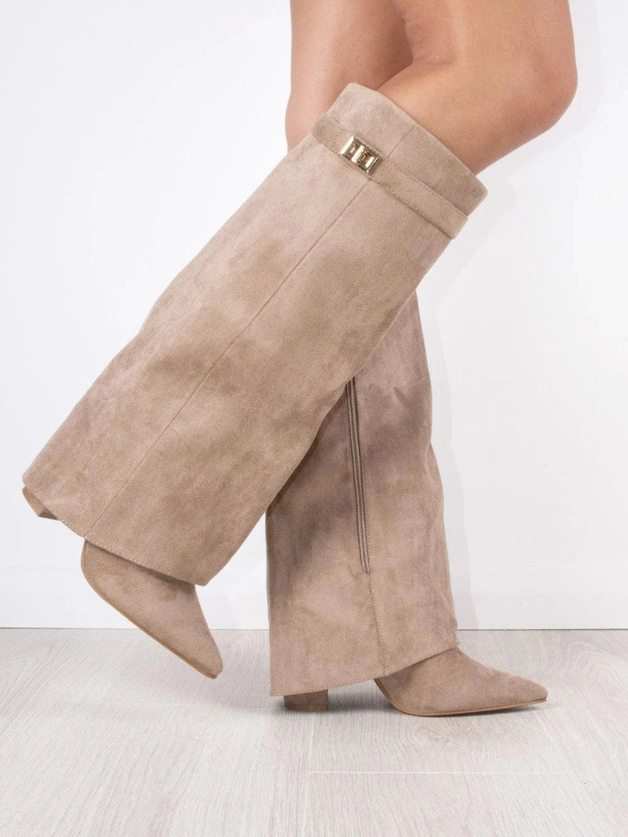 Taupe suede-look fold-over knee boots on a model mid-step, showing the side zip and gold turn-lock strap. 13