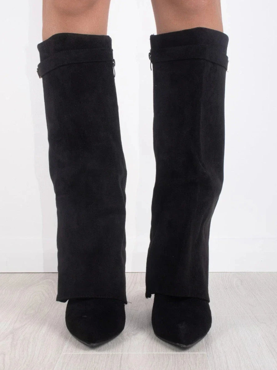 Front view of black suede-look fold-over knee boots worn by a model, with pointed toes and straps at the top. 3