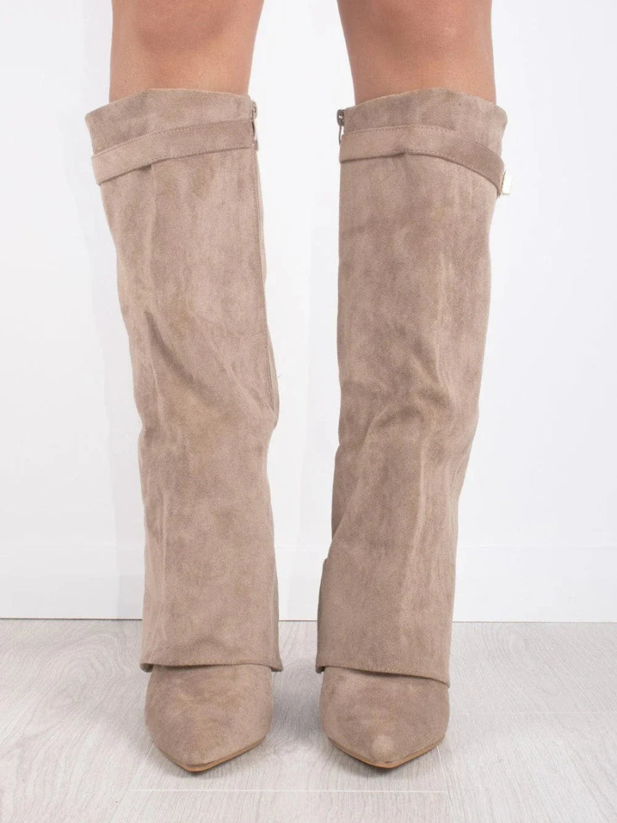 Front view of taupe suede-look fold-over knee boots with pointed toes, worn by a model against a white wall. 5