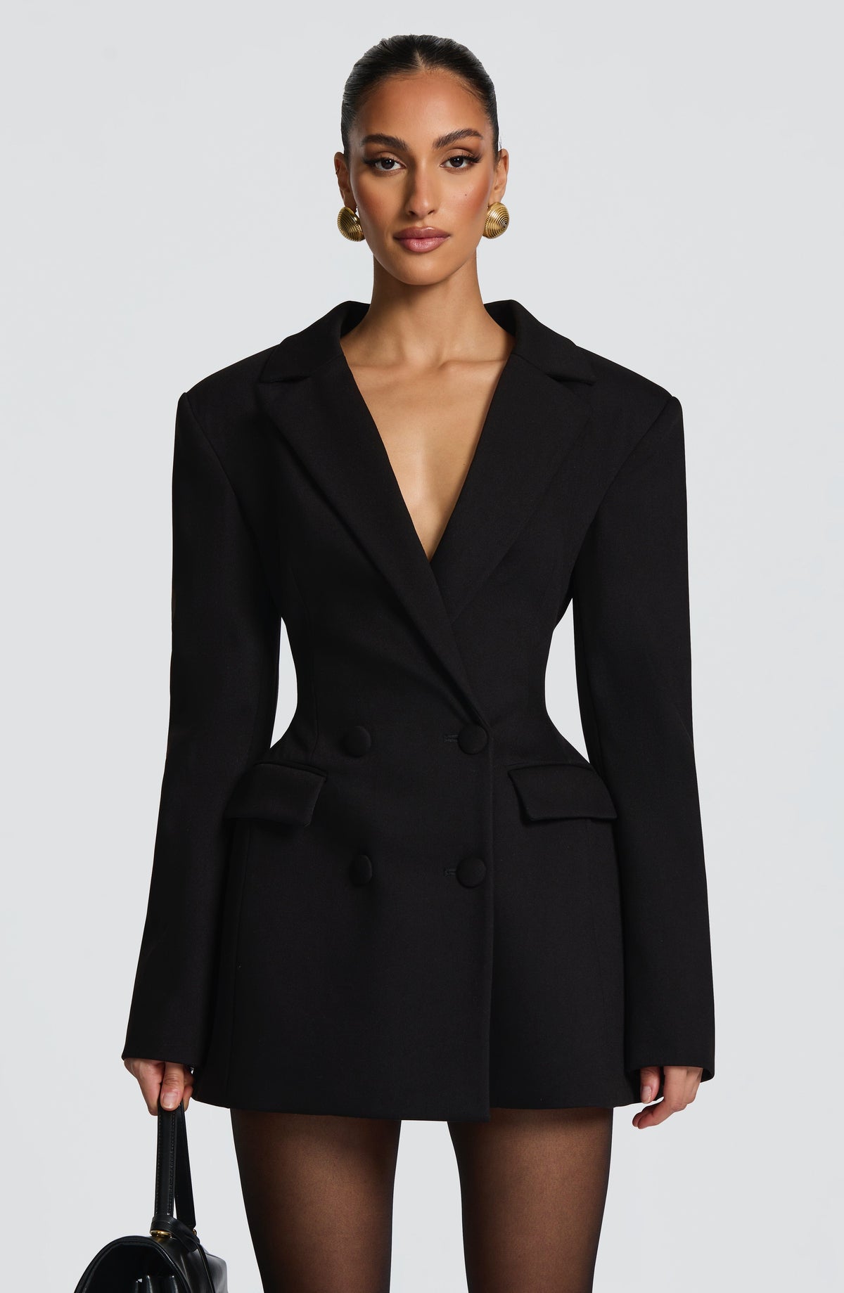 Close front view of the black double-breasted blazer dress, showing structured shoulders, flap pockets and covered buttons. 6