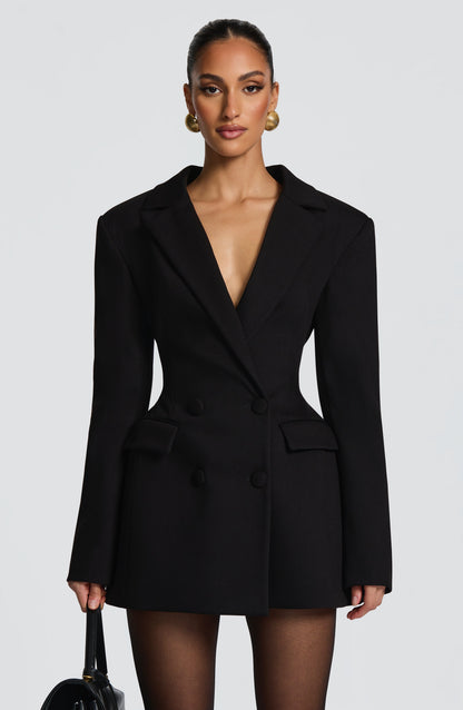 Close front view of the black double-breasted blazer dress, showing structured shoulders, flap pockets and covered buttons. 6