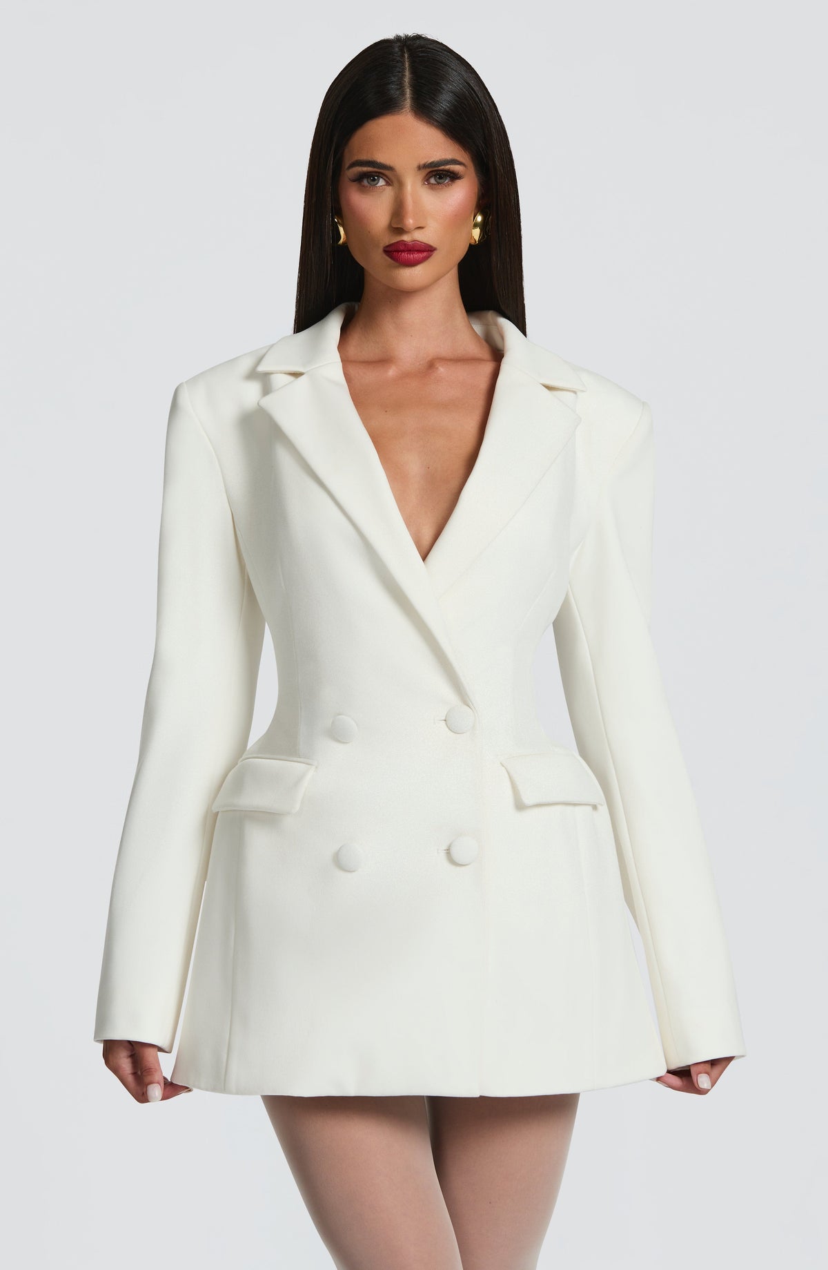 Front view of the ivory blazer dress on a model with straight dark hair and gold earrings, arms slightly out. 17