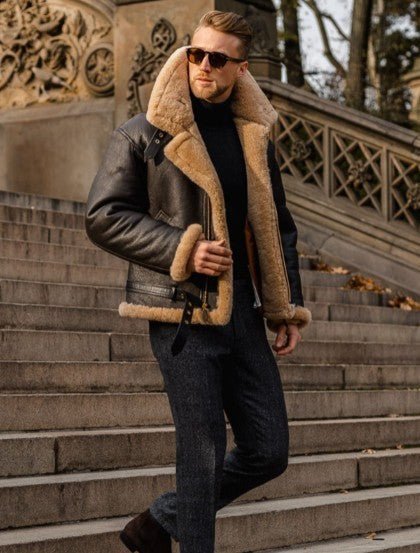 Man in sunglasses wearing the shearling-lined leather jacket with a black roll neck on stone steps 3