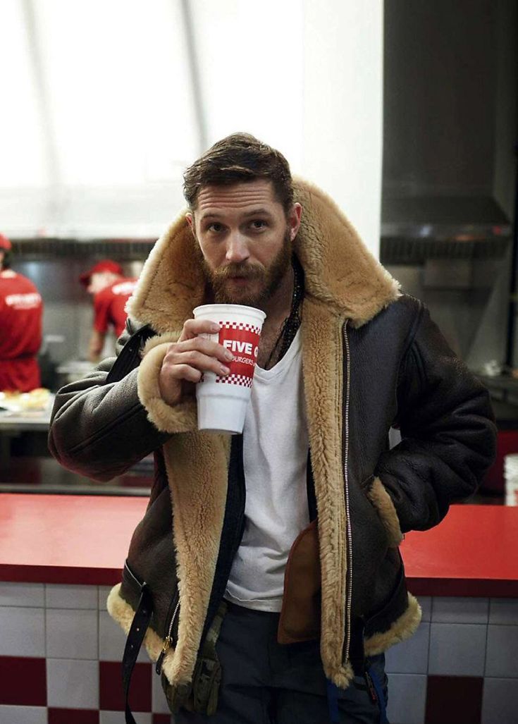 Bearded man wearing the jacket with a white t-shirt, holding a drinks cup in a diner 4