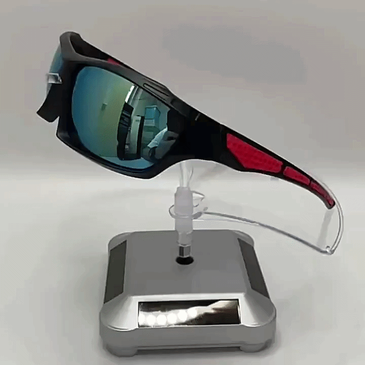 Sunglasses with mirrored lenses and red patterned arms displayed on a clear stand on a silver rotating base 4
