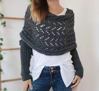 Close front view of the dark grey wrap, showing the openwork lace panel and ribbed sleeves over a white top. 3