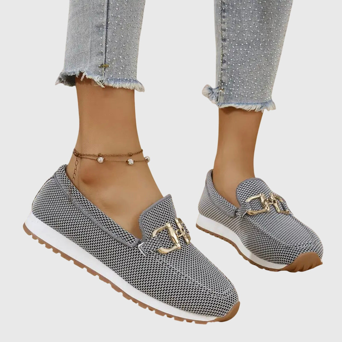 Grey and black mesh slip-ons with gold buckle, side view on a model with studded jeans 4