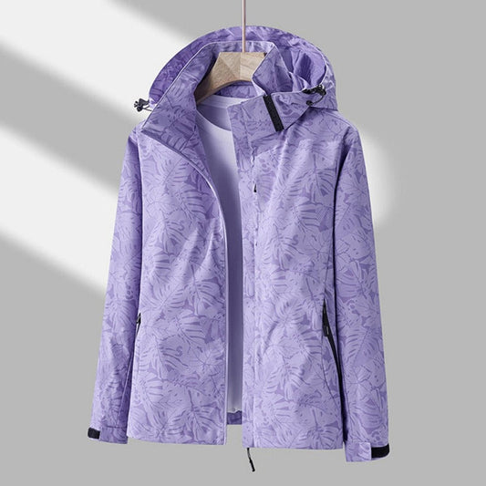 Hooded zip-up jacket in lilac with a tonal tropical leaf print, shown open on a wooden hanger over a plain top. 1