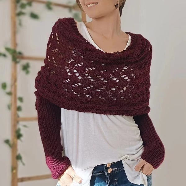 Burgundy wrap with generous cowl neckline and ribbed sleeves, worn with a white top and hands in pockets. 19